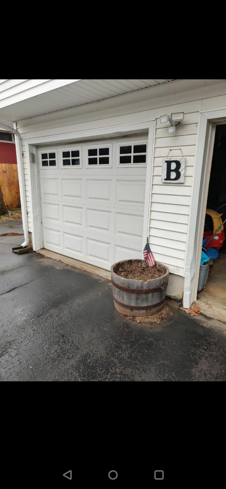 White raised-panel garage door with windows on residential property
